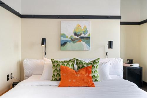 匹兹堡The Maverick by Kasa的卧室配有带橙色枕头的白色床