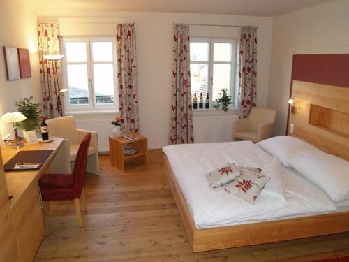 Gobelsburg科班肖夫农家乐的酒店客房配有一张床、一张书桌和一张书桌。