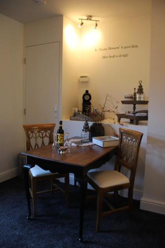 AssendelftStudio Bed and Breakfast Zaans Moment的餐桌、椅子和墙上的写字