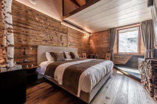 帕苏德尔托纳莱CAPANNA PRESENA的一间卧室设有一张床和木墙