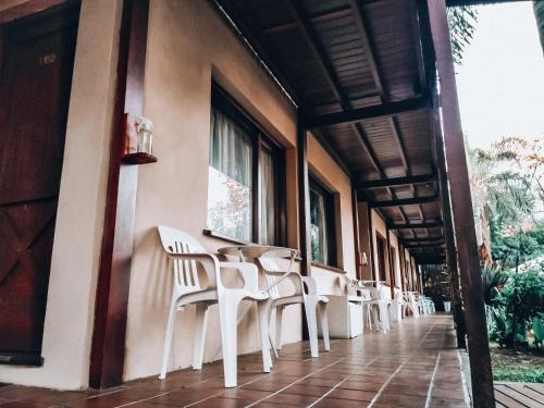 圣佩德罗Hotel Los Pinares的坐在建筑物边的一排白色椅子