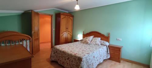 CortinaApartamentos Casa Alvarina - Luarca的一间卧室设有床铺和绿色的墙壁
