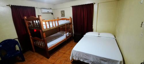 玉米岛Tropical Dreams Hostel的小房间设有两张双层床和梯子