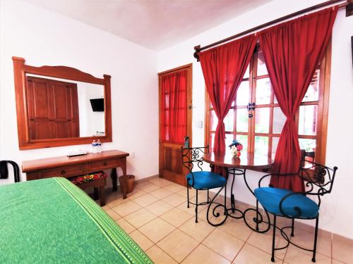 瓦哈卡市Hotel Casa de la Tía Tere的一间卧室配有桌椅和镜子