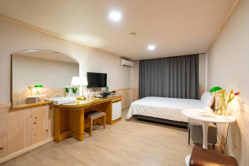 济州市新济州酒店的酒店客房设有床和水槽