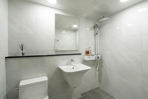 济州市新济州酒店的白色的浴室设有卫生间和水槽。