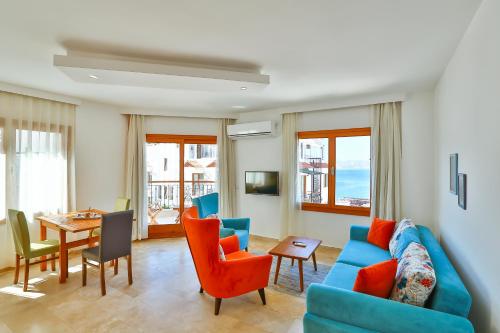 卡斯Çınarlar Apart Hotel KAŞ的客厅配有蓝色的沙发、椅子和桌子