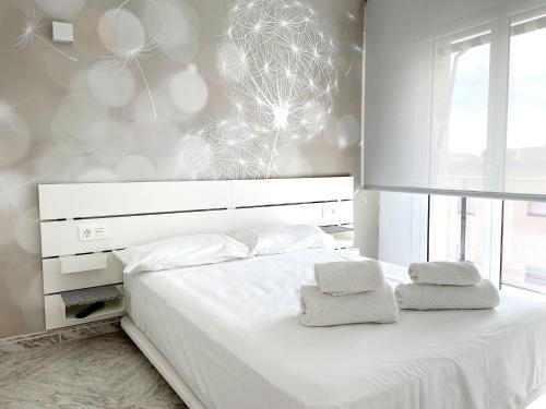埃勒凡达尔Open Sky, Apartamento con solárium privado y barbacoa的卧室配有白色的床和2条毛巾