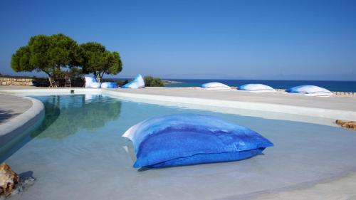 艾拉方索斯Eight Dimensions Capari Suites Elafonisos的游泳池畔的蓝色遮阳伞