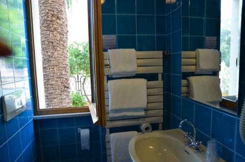 马达莱纳码头别墅酒店的蓝色瓷砖浴室设有水槽和镜子