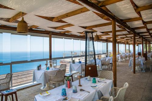 普莱伊亚诺玛格丽塔酒店的一间带桌椅的海景餐厅