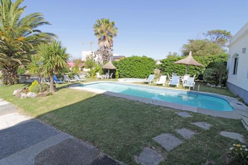 皮里亚波利斯Hotel Mesón Do Vento的庭院内的游泳池,带椅子和树木