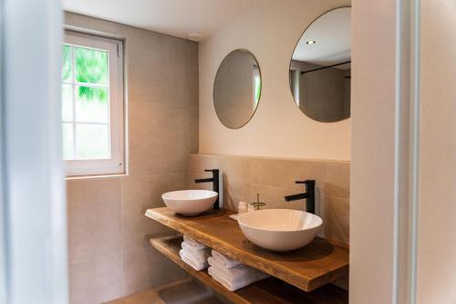 埃尔默洛Bed en Wellness Groenrust的浴室设有2个水槽和2个镜子