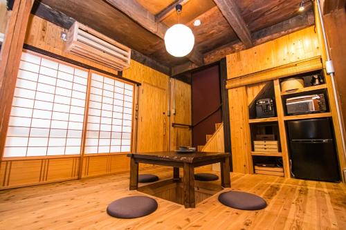 福冈Machiya Villa Seian - Vacation STAY 11749的木墙客房内的厨房配有桌子