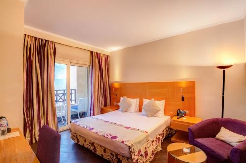 艾因苏赫纳Porto El Jabal Hotel的配有一张床和一把椅子的酒店客房
