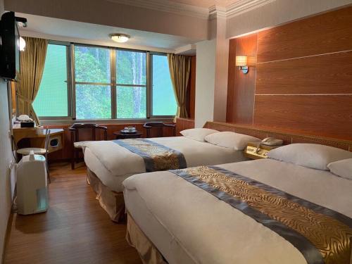 中正高峰大饭店的酒店客房设有三张床和窗户。