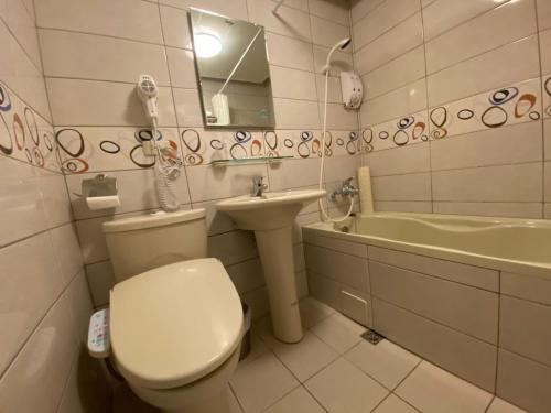 中正高峰大饭店的浴室配有卫生间、盥洗盆和浴缸。
