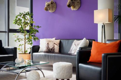 德累斯顿德勒斯顿贝斯特韦斯特马克雷登酒店的客厅配有紫色墙壁和沙发
