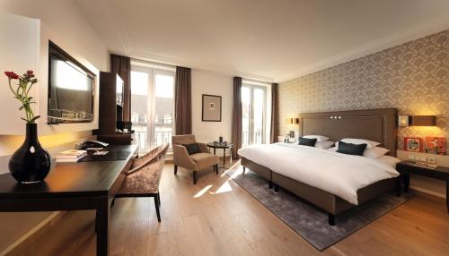 奥格斯堡Hotel Maximilian’s的酒店客房配有一张床、一张书桌和一张书桌。
