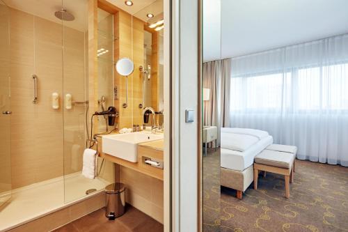 萨尔茨堡H+萨尔茨堡酒店 的一间带水槽和淋浴的浴室