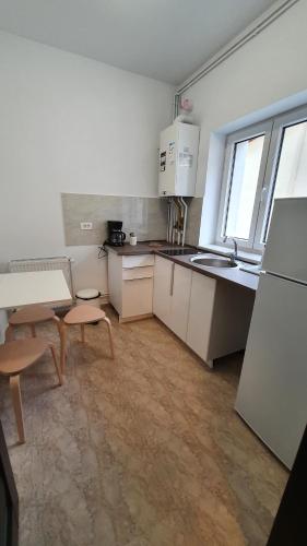 布加勒斯特Casa Florescu 13的厨房配有白色橱柜、桌子和水槽。