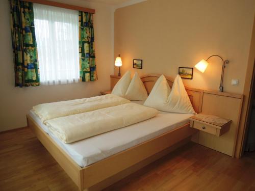 施特罗布尔Appartements Edda的一间卧室配有一张带白色床单的床和一扇窗户。