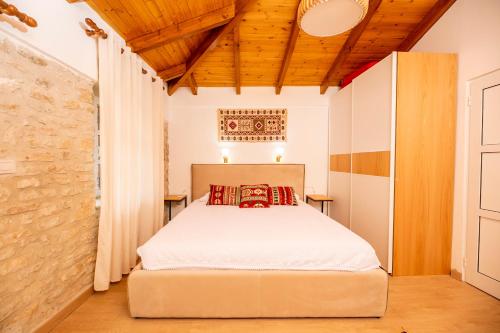 科帕罗Vila Leon - Old Qeparo的一间卧室设有一张床和木制天花板