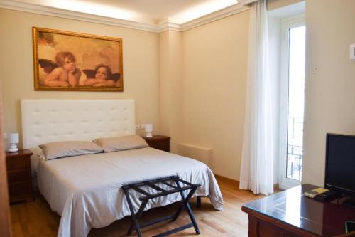 罗马Hotel Salis的卧室配有一张床,墙上挂有绘画作品