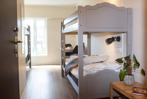 利勒哈默尔Lillehammer Stasjonen Hostel的客房设有双层床和桌子。