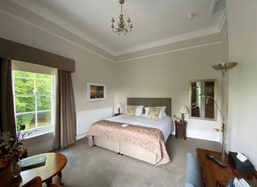 赖盖特Reigate Manor Hotel的一间卧室配有一张床、一张桌子和一张沙发