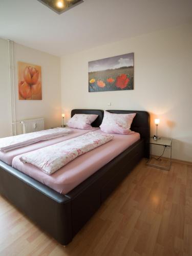 萨尔布吕肯Ferienwohnung Fernblick的卧室内的一张大床,配有两盏灯
