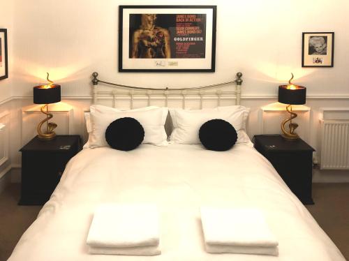 惠特比High Tor Guest House的卧室配有带两盏灯的白色床