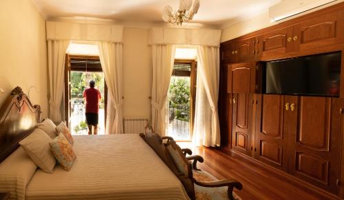 普里埃格·德·科尔多巴Alojamiento Turístico Fuente del Rey的一间卧室配有一张床和电视,窗户上的人