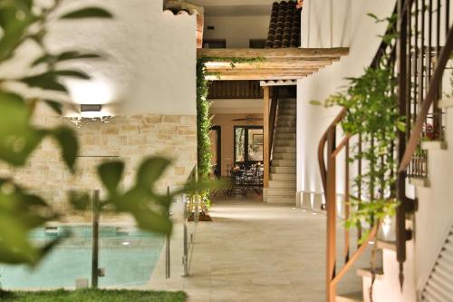 孔苏埃格拉El Patio de los Jazmines Boutique-House的一个带游泳池的房子的走廊