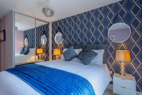金斯兰利LillyRose Apartments - Hemel Hempstead, Free Parking, Free Wi-Fi的一间卧室配有一张带蓝色床单和镜子的床