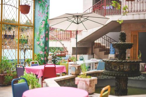 朱尼耶Damask Rose, Lebanese Guest House的一个带桌椅和遮阳伞的庭院
