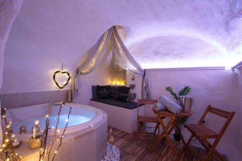 普罗旺斯艾克斯Les Secrets d'Alcôve, nuits Romantiques avec SPA的带浴缸的浴室和带窗户的客房