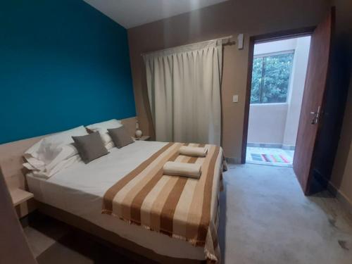 亚松森Taguato B & B的一间卧室设有一张蓝色墙壁的大床