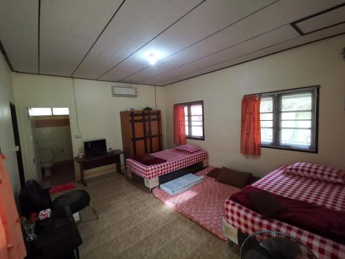 卡农快乐度假村 的一间设有两张床和一张桌子的房间