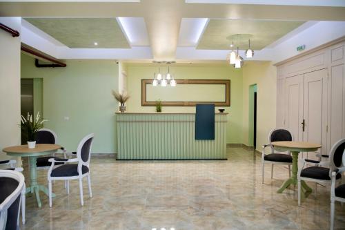 百乐·奥拉内斯蒂Imperial Hotel&Spa - Baile Olanesti的一间设有桌椅和投影屏幕的等候室