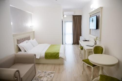 百乐·奥拉内斯蒂Imperial Hotel&Spa - Baile Olanesti的一间卧室配有一张床、一张桌子和一张桌子