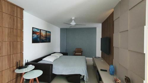 阿拉亚尔-杜卡布Apartamento Ninho das Gaivotas - Praia dos Anjos Residence - 2 Vagas的一间带床和电视的小卧室