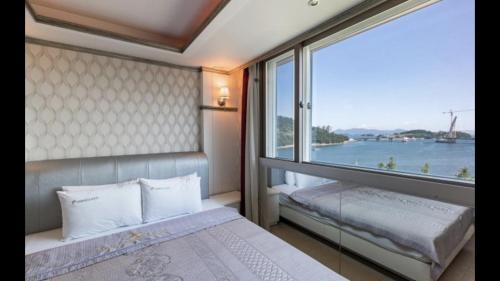 丽水市Yeosu Beach Hotel的一间卧室设有一张床和一个大窗户