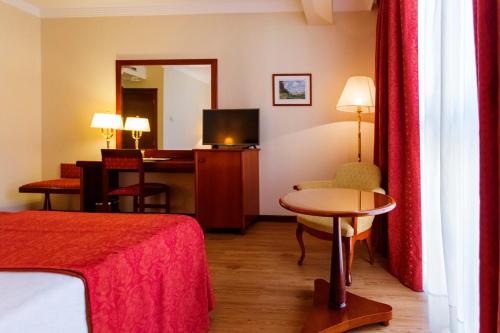 费罗尔德费罗尔大酒店的酒店客房配有一张床铺、一张桌子和一张书桌。