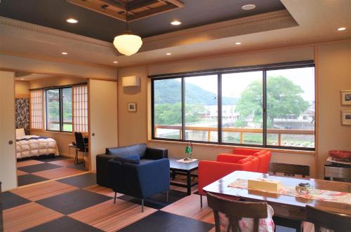 IbaraIBARA DENIM HOTELS 舞鶴楼的客厅配有桌椅和窗户。