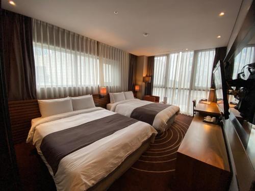 釜山路易斯汉密尔顿百斯特酒店海云台的带窗户的酒店客房内的两张床