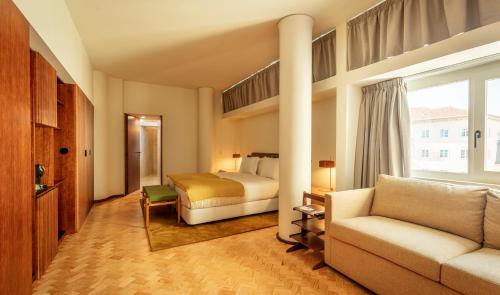 波尔图Ceuta Terrace Suites的酒店客房,配有床和沙发