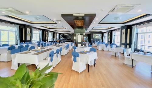 吉婆岛卡巴海珠酒店的用餐室配有白色的桌子和蓝色的椅子