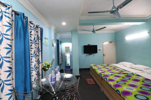 加尔各答Hotel Airways的一间卧室配有一张床、一张桌子和一台电视