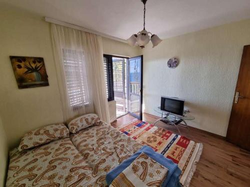 尤塔哈Дом для семейного отдыха в Утехе, Черногория的一间卧室配有一张床和一台平面电视